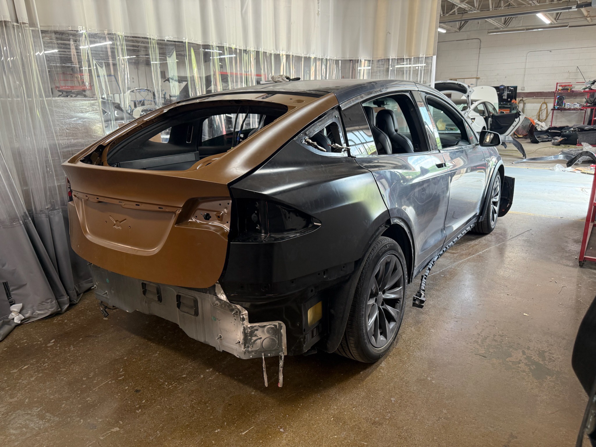 Collision-damaged SUV undergoing structural repair in a professional body shop